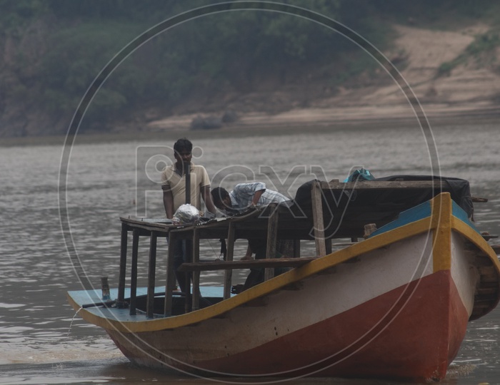 Two men standing in the boat parked at river godavari.