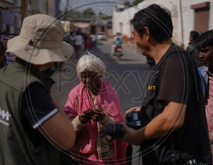 An Old Lady Asking Photographers For money  in Pushkar