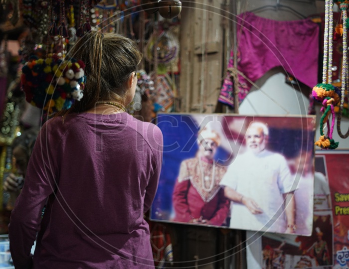 A Woman Sited Looking Into a Placard Of Indian PM Narendra Modi in Vending Shops in Pushkar Fair