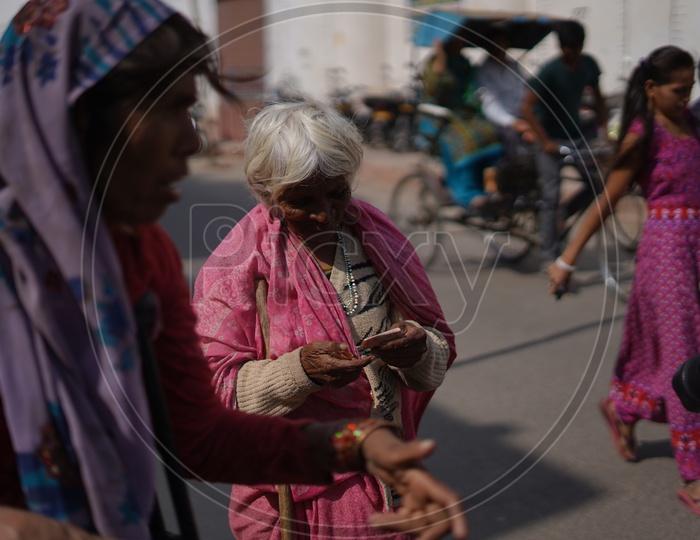 An Old Lady Asking Photographers For money  in Pushkar
