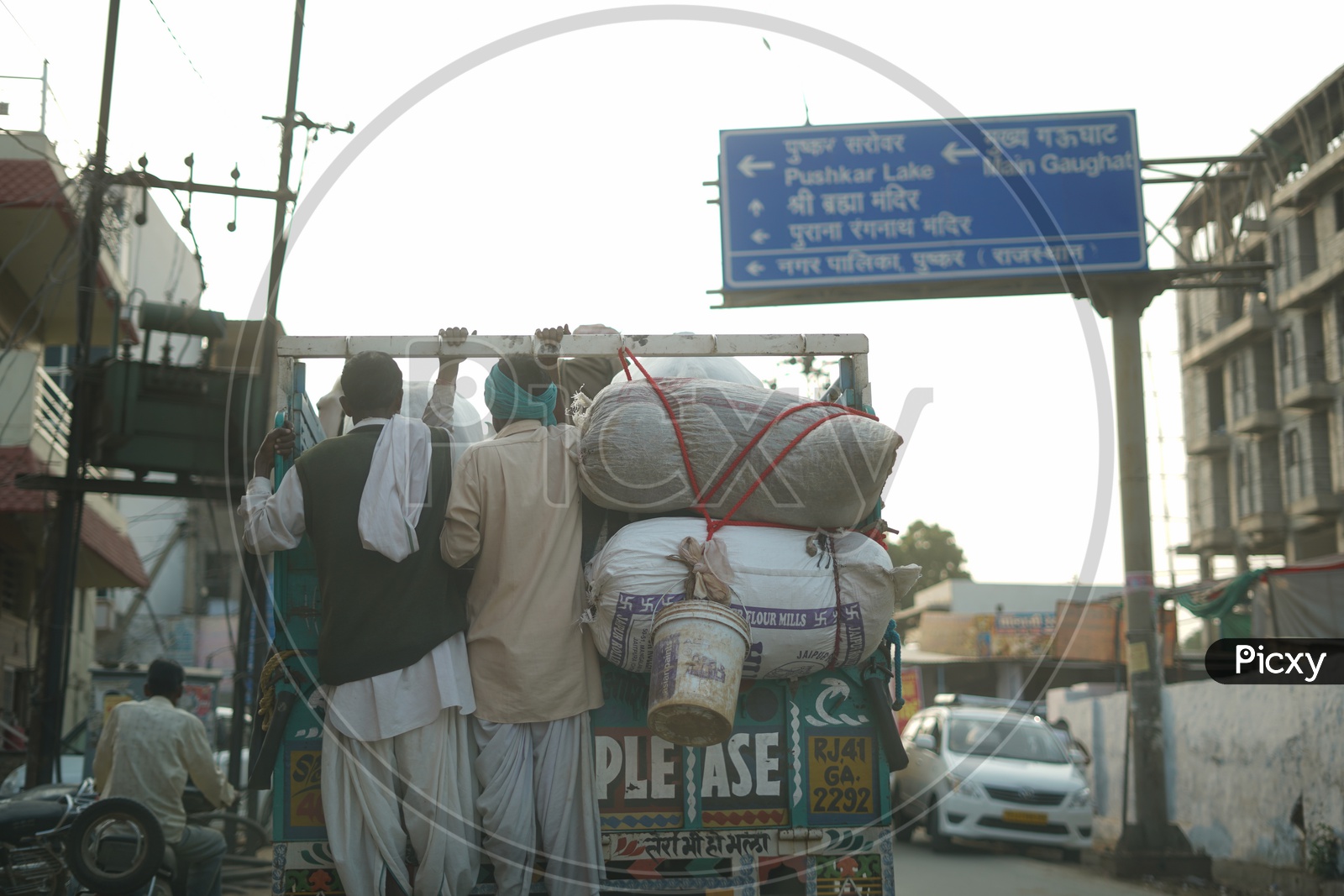 Local People In Pushkar Commuting Dangerously by Hanging on to Backside of Vehicle in Pushkar