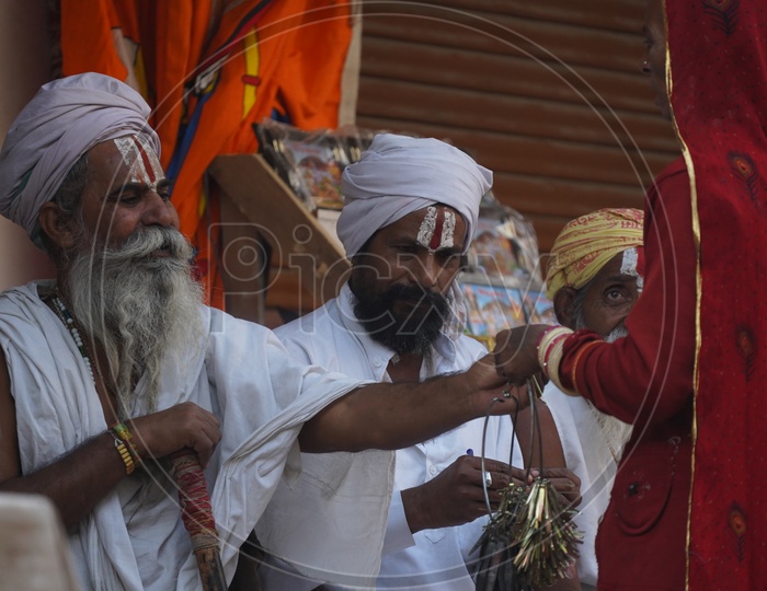 A rajasthani Woman Vendor Selling Turban Clips to Indian Sadhus / Babas