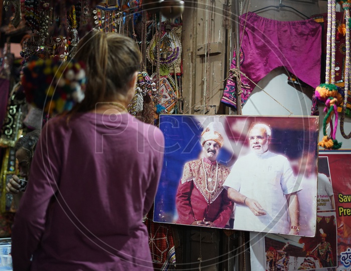 A Woman Looking Into a Placard In a Vending Shops in Pushkar Fair in Which Narendra Modi Sited
