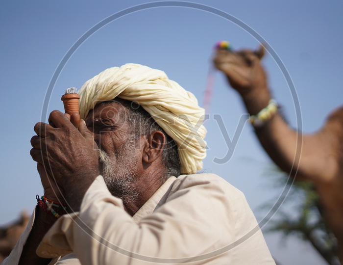 An Old Man Smoking Marijuana / Ganja  in Pushkar Camel Fair