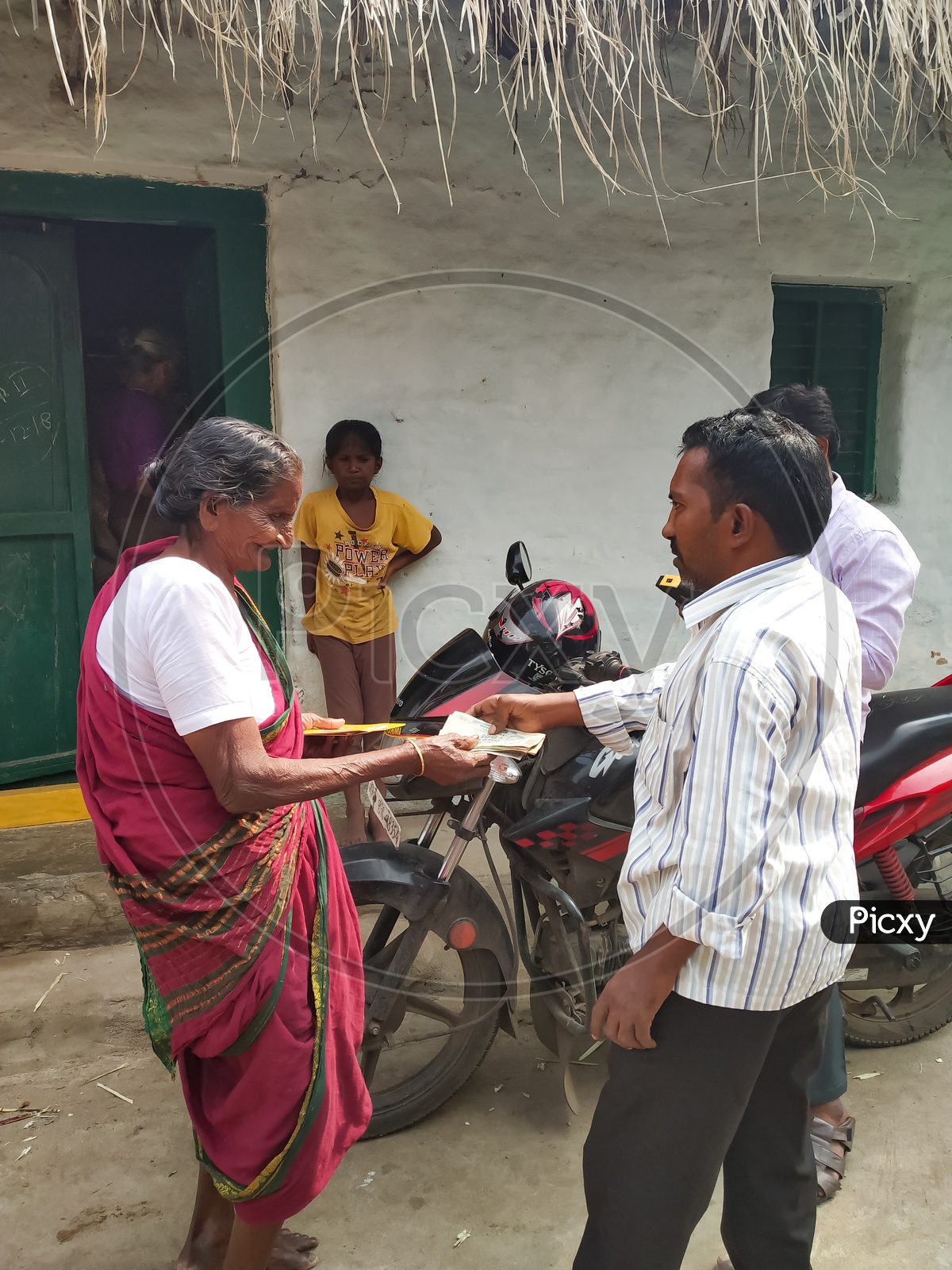 An Old Lady Receiving Her Monthly Pension From Andhra Pradesh  Government Officers At Her Door Step