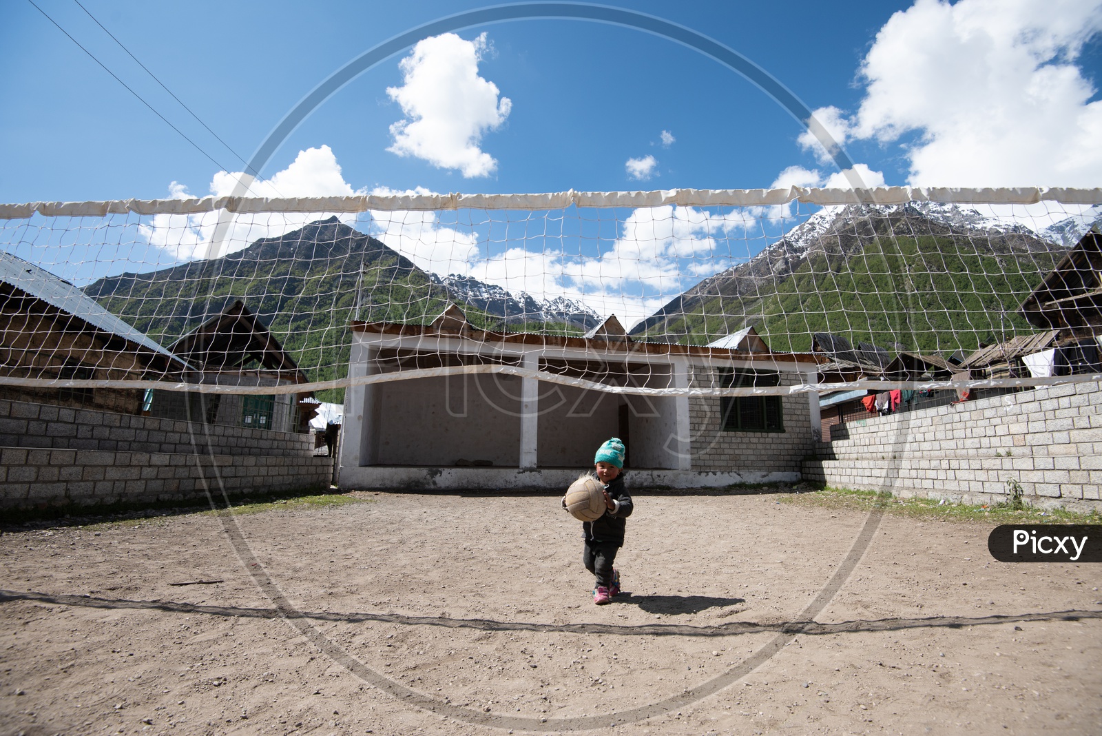 Child in Spiti Valley Playing with Ball in Volleyball Court