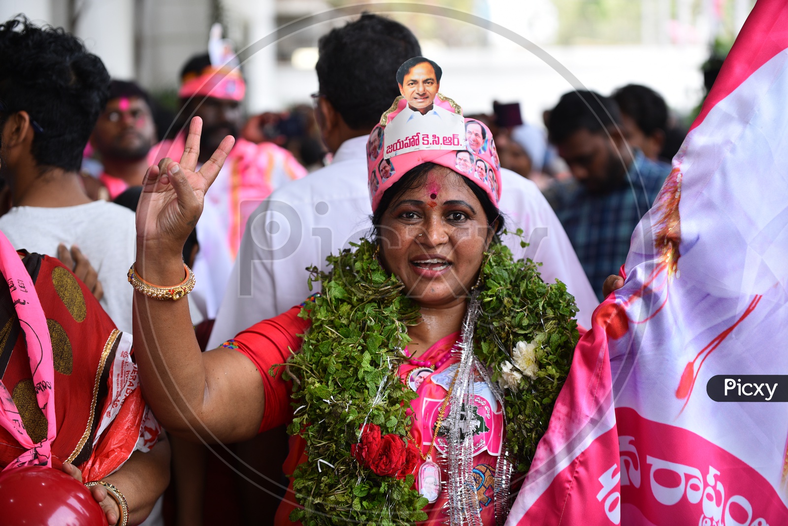 A Lady  Supporter Of TRS Party Wearing TRS Cap with KCR Photo in it In Celebrations of Victory in Telangana Elections 2018