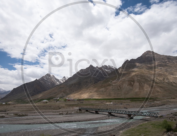 Beautiful Snow capped mountains of Spiti Valley with a bridge in the foreground