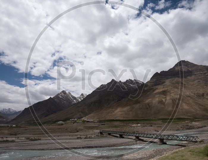 Beautiful Snow capped mountains of Spiti Valley with a bridge in the foreground
