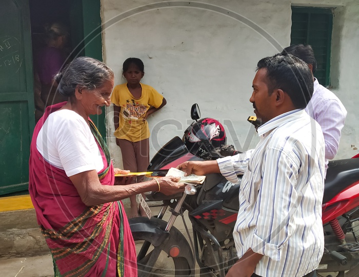 An Old Lady Receiving Her Monthly Pension From Andhra Pradesh  Government Officers At Her Door Step