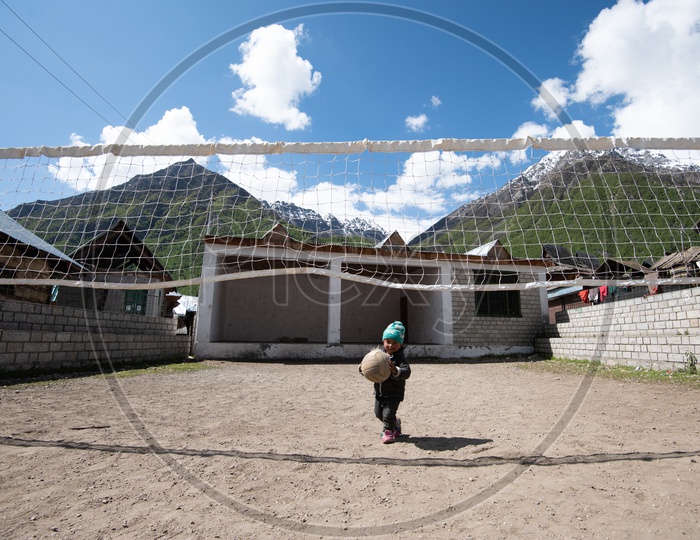 Child in Spiti Valley Playing with Ball in Volleyball Court