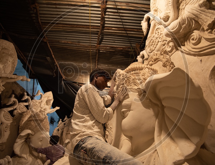 An Artist Giving Finisings  to Ganesh Idols made of Plaster of paris