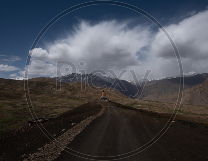 Road in Ladakh Leading To a Buddha Statue With Dunes, Sky and clouds in  Backdrop