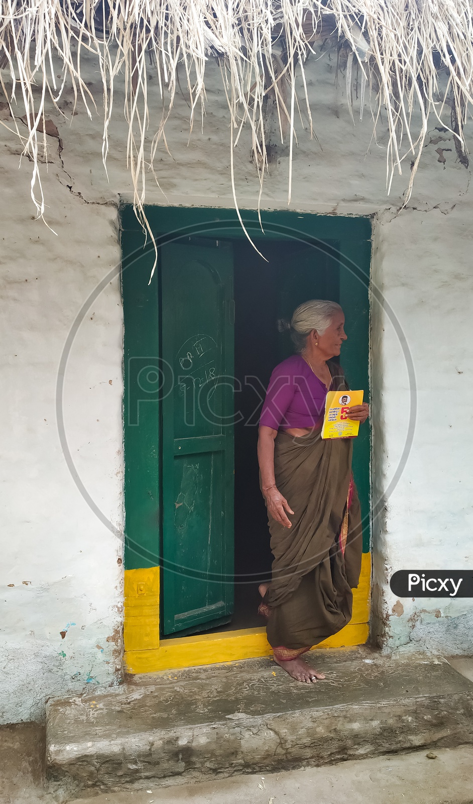 An Old Lady With Her Pension Card in Her Hand  Waiting at Door Step in Andhra Pradesh