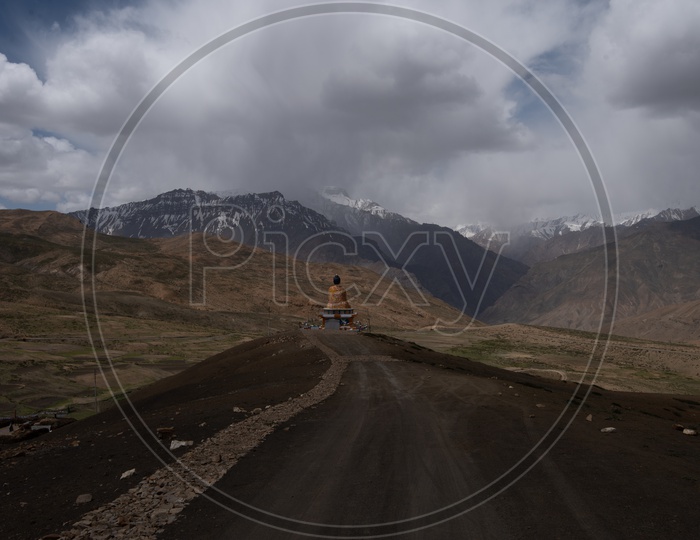 Road in Ladakh Leading To a Buddha Statue With Dunes, Sky and clouds in  Backdrop