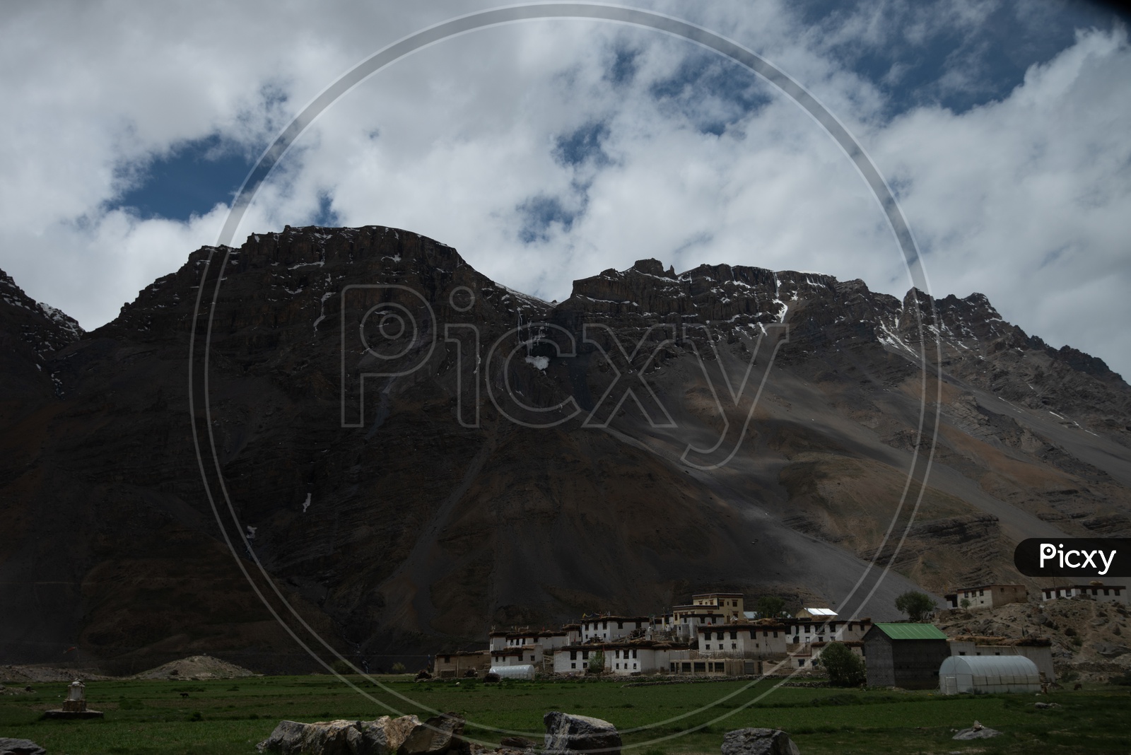 Beautiful Landscape of Snow Capped Mountains of Spiti Valley with buildings  in the foreground