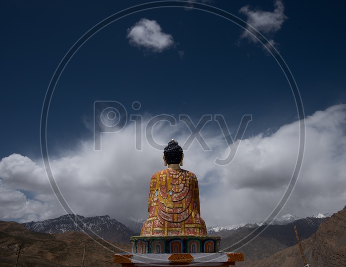A Buddha Statue with Sky and Mountains in Background