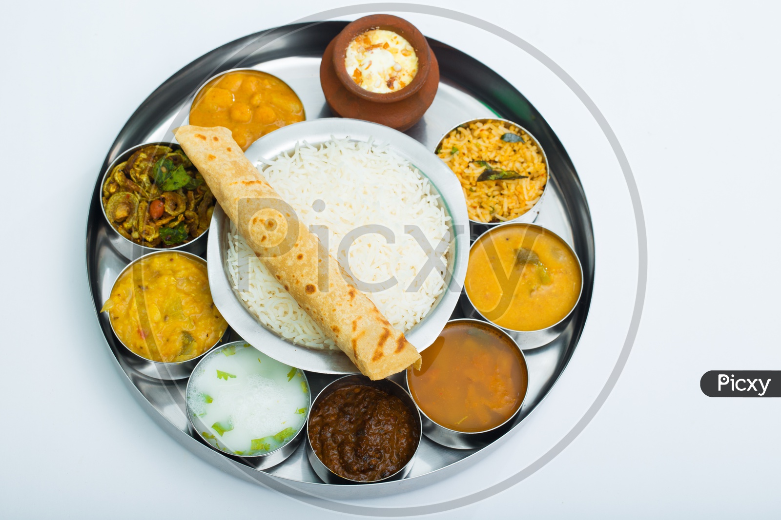 Indian Thali / Lunch / Dinner With Rice Bowl, Roti and Cups with Different Dishes Presentation Composition Shot with White Background
