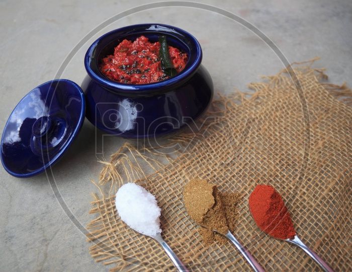 Indian Homemade Tomato Pickle / Achar Composition Shot With Ingredients in Spoons Presentation