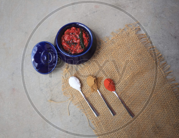 Indian Homemade Tomato Pickle / Achar  Composition Shot With Ingredients In Spoons  Presentation