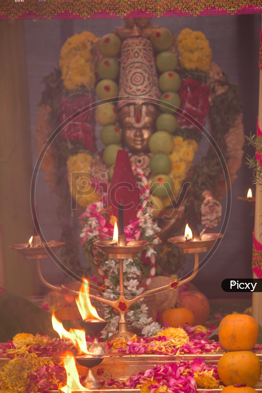 ayyappa swami idol covered with fruits in pooja