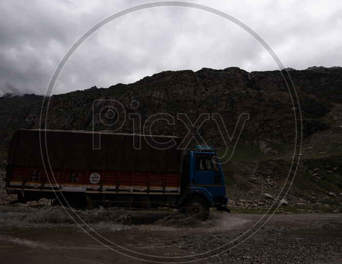 A Vehicle Crossing  a Water Pit On Road Of  Leh / Ladakh