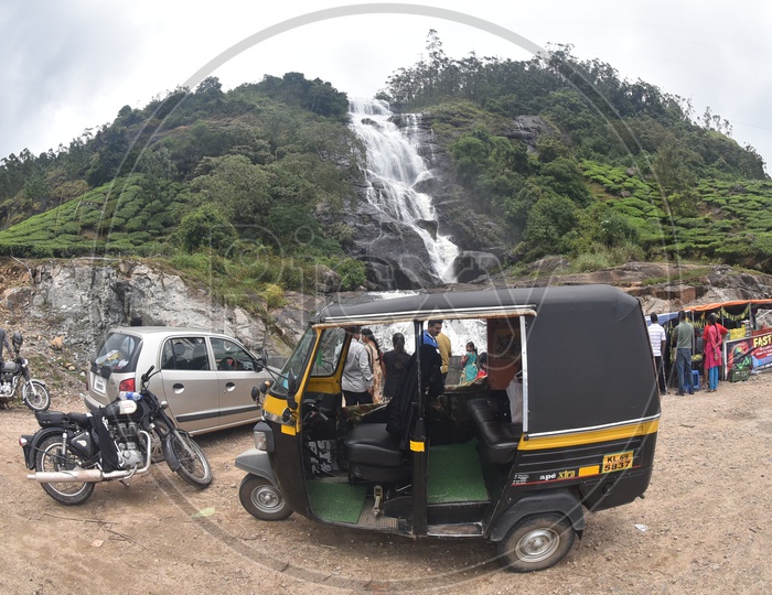 Tourists and Local Transport Vehicles at a Water falls in Munnar Falling From  a hill Top