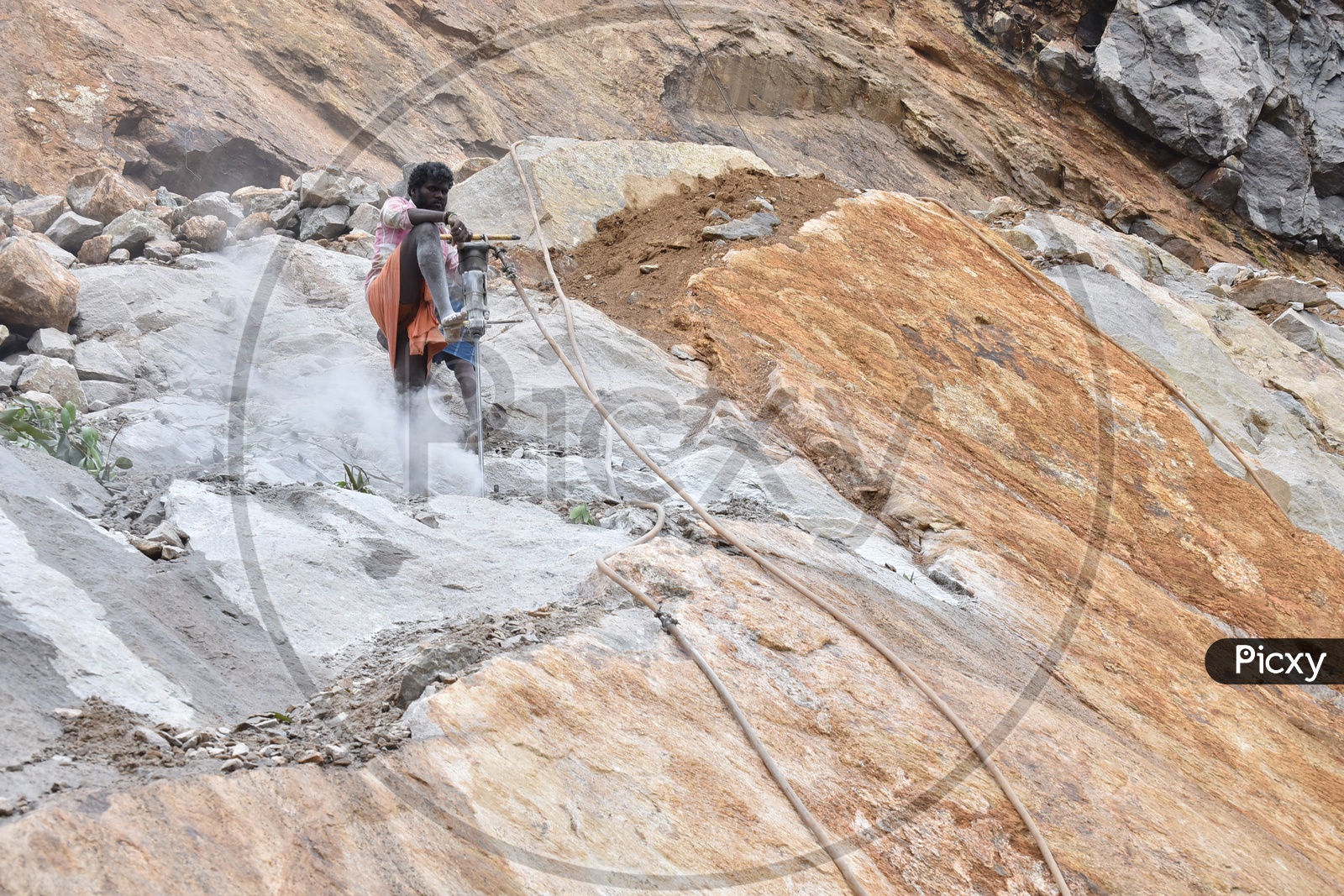 A Drilling Worker Working on a Hill With Stones  in Munnar