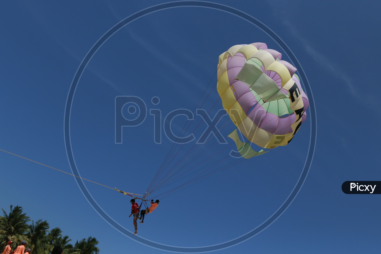 Two ParaGliders Tandem Flying against a Blue Sky