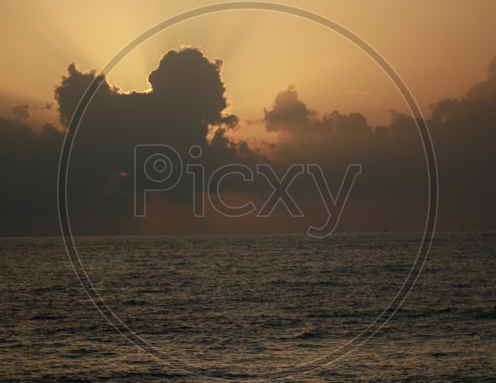 Silhouette Of Cloud in a Golden hour Sun and Sea in Foreground
