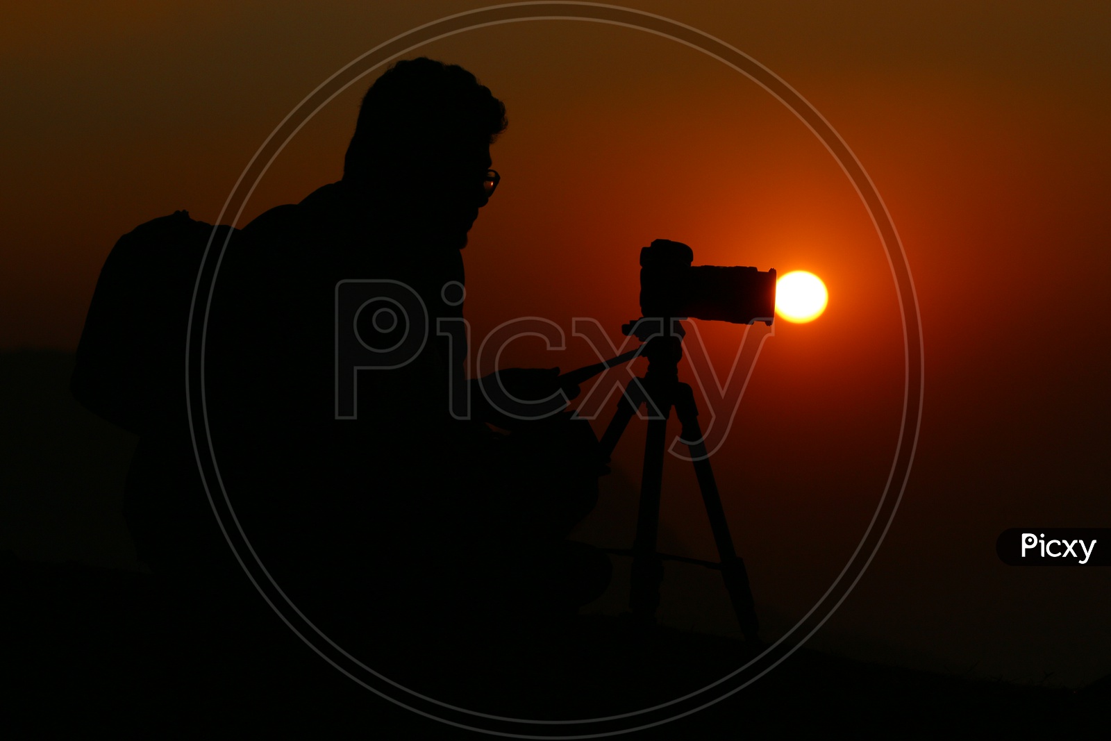 Silhouette Of a Photographer Over a Sunset