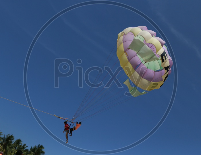 Two ParaGliders Tandem Flying against a Blue Sky