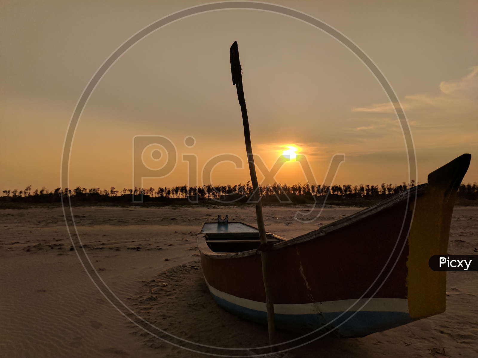 A Lone Boat In a Beach With Sand and Sunset In Background