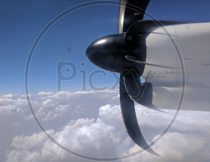 Flight Propellers Shot from Window Of a Plane With Clouds and Sky In Background