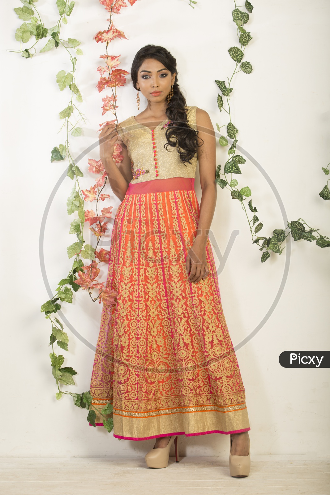 Indian girl dressed up in orange dress portrait in Studio Lighting / Traditionally dressed up girl