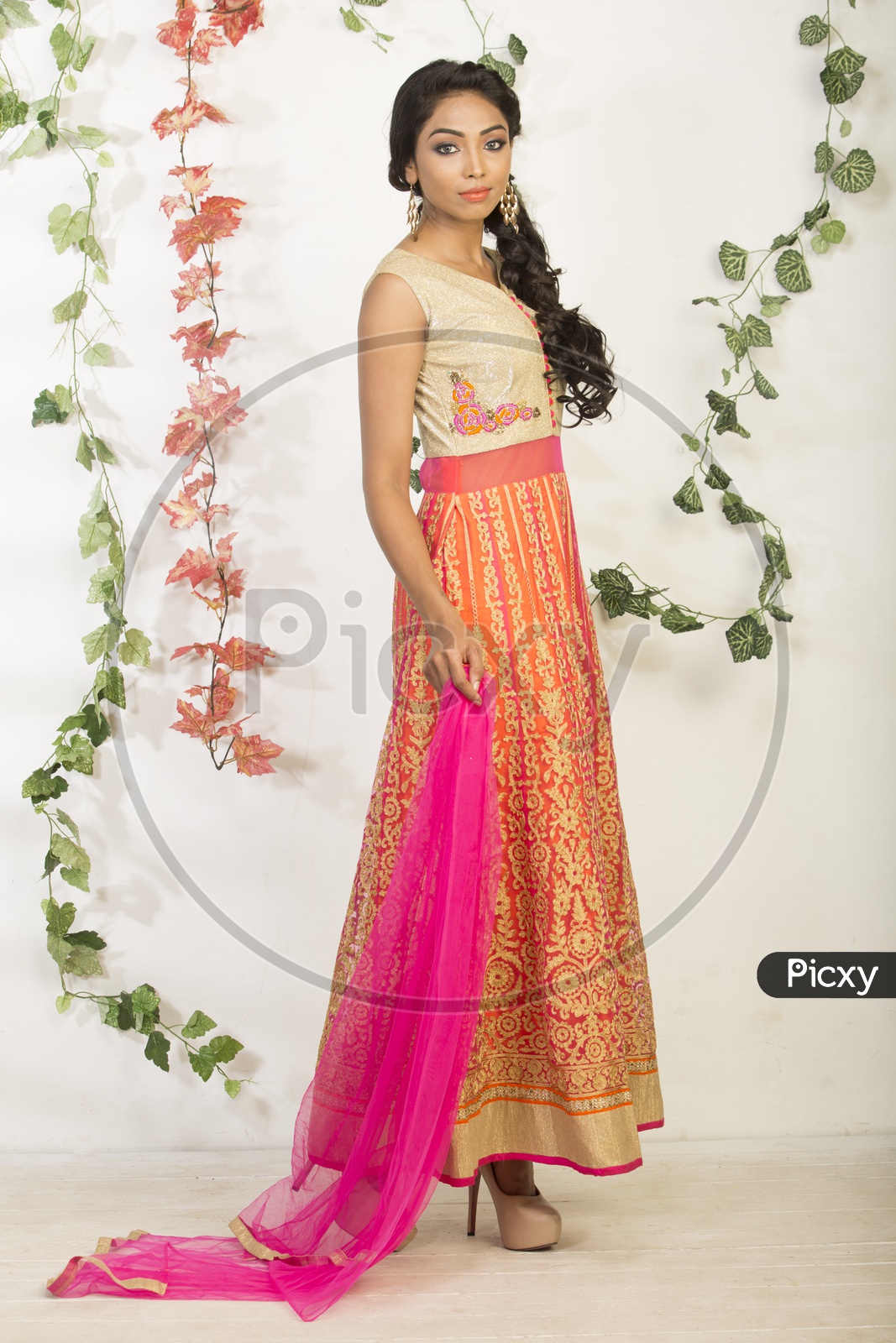 An Indian Female Model Wearing a Colorful  Chudidar Over  a Studio Setup and Smiling Looking to Camera