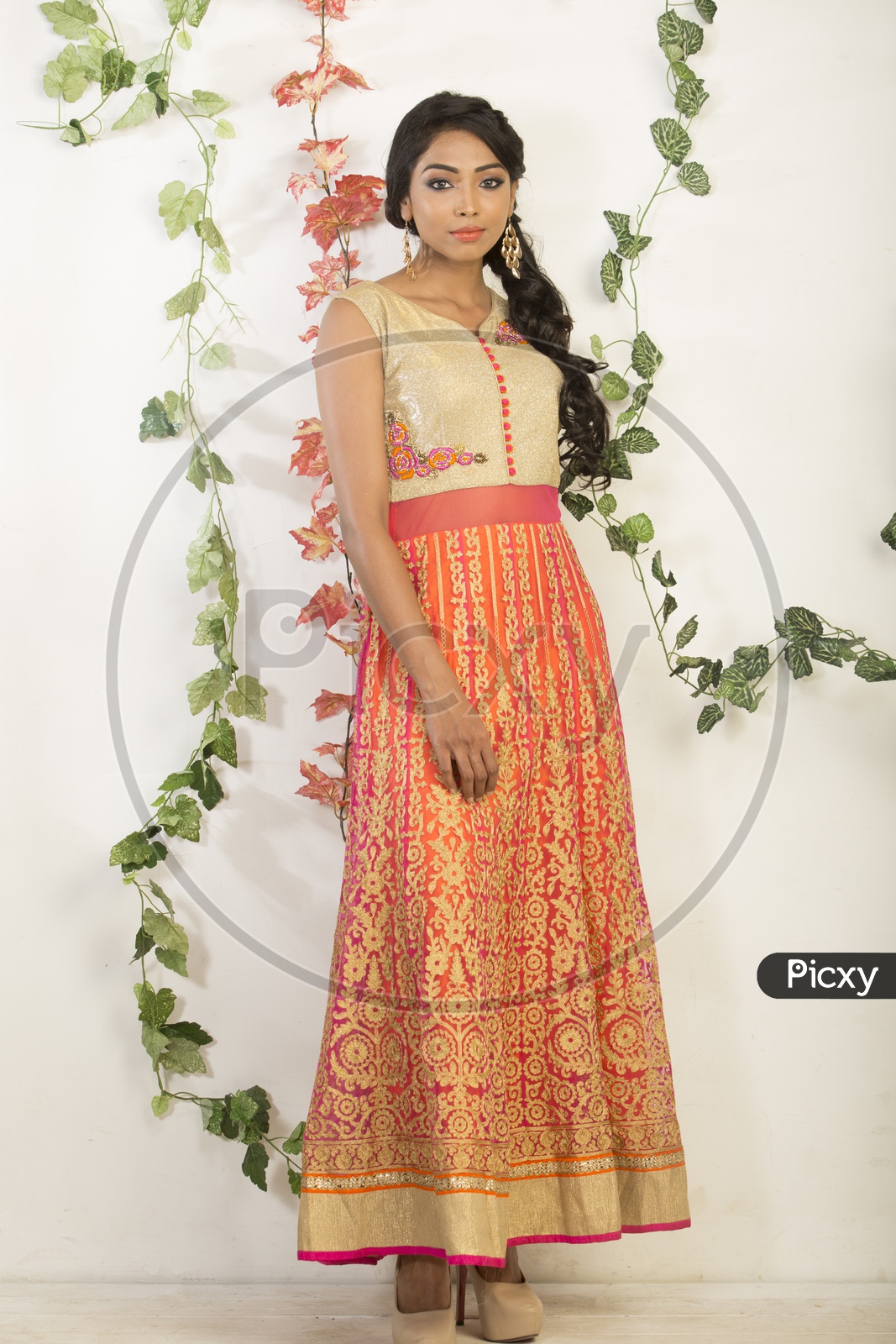 Indian girl dressed up in orange dress portrait in Studio Lighting / Traditionally dressed up girl