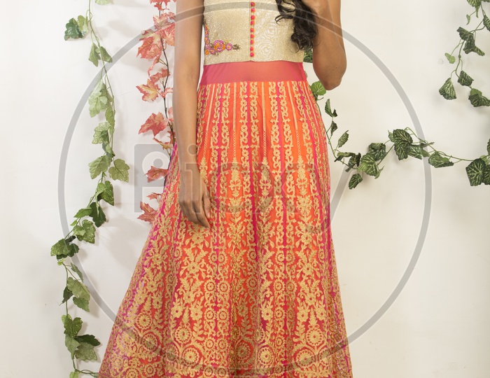 Indian girl dressed up in orange dress portrait in Studio Lighting / Traditionally dressed up Model