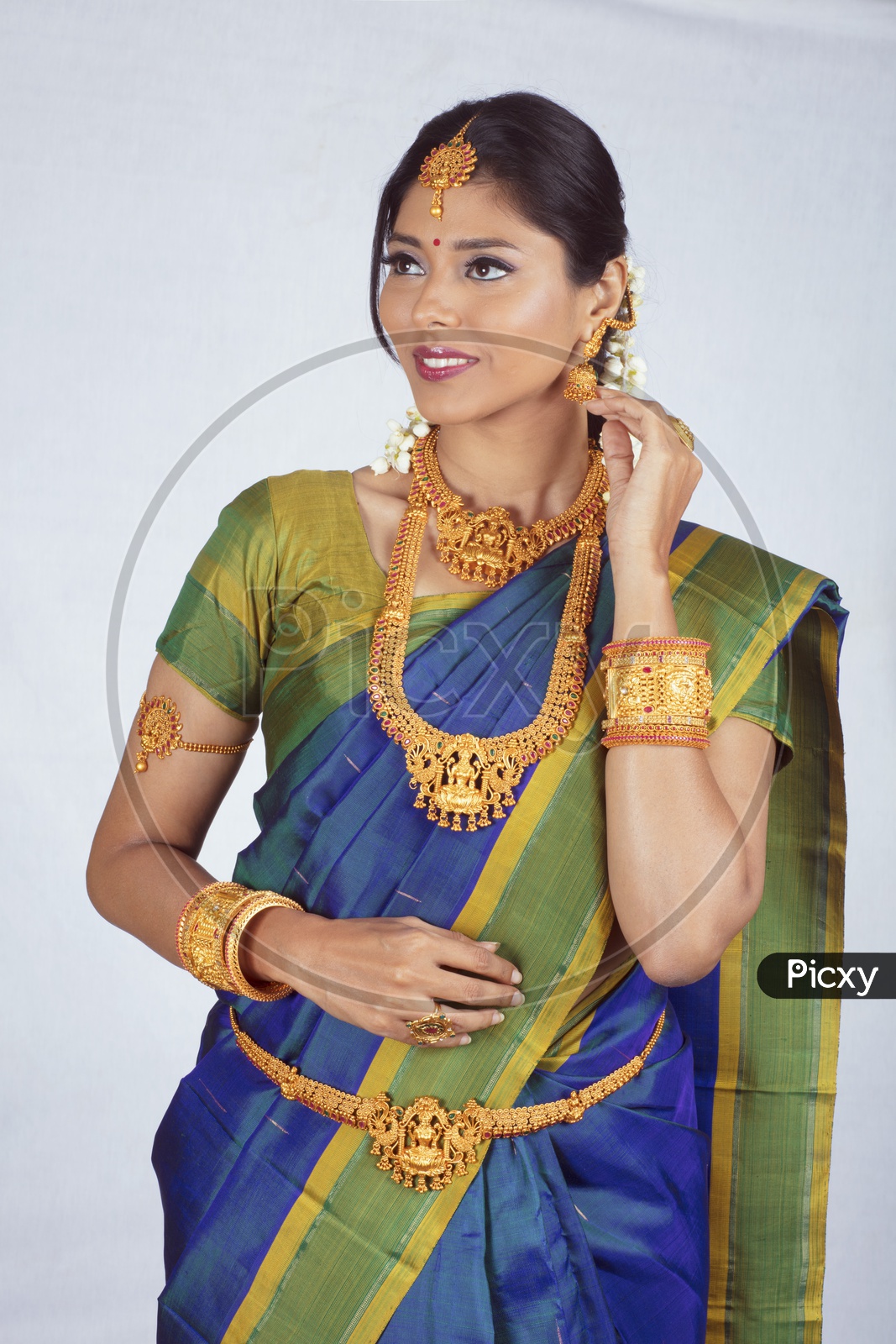 Traditional Indian Female/Woman Model in Blue Saree, green Blouse - Showing her earrings