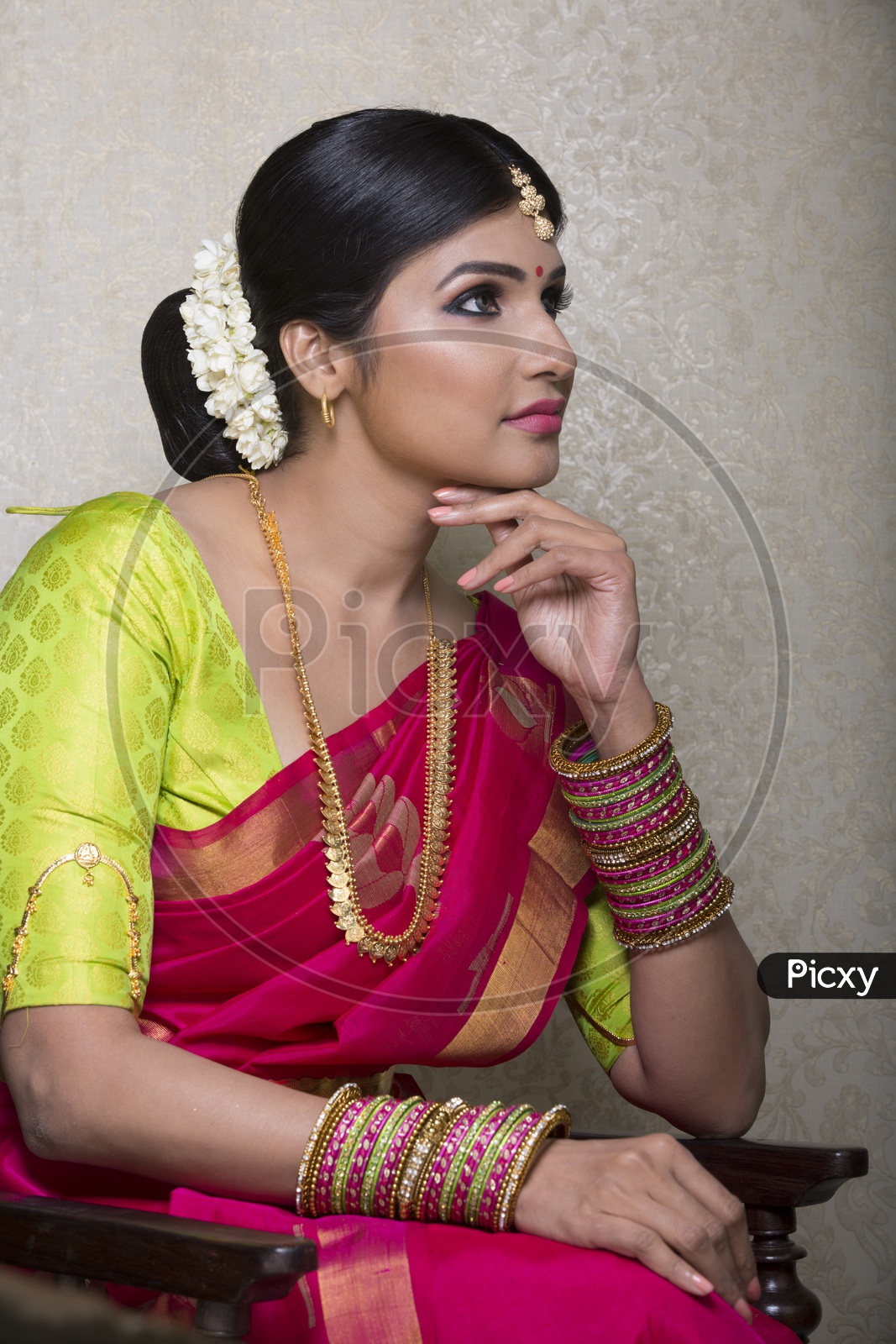 A Beautiful Indian Female Model  in Traditional Attire Wearing a Saree and Jewelry with an Expression  on an Studio Closeup shot