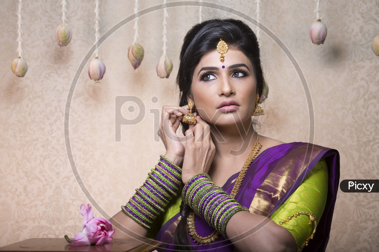 Traditional Indian Female/Woman Model in Purple Saree, green Blouse with a Lotus flower