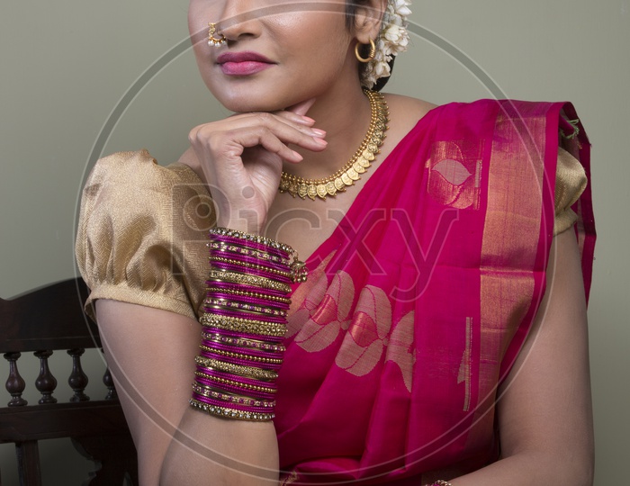 Indian Bride dressed up in red saree portrait in Studio Lighting / Traditionally dressed up girl