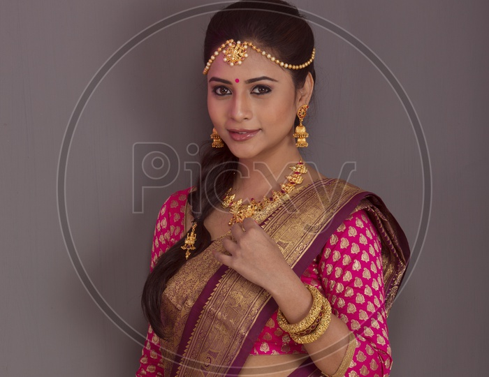 Indian bride dressed up in red saree  portrait in Studio Lighting / Traditionally dressed up girl