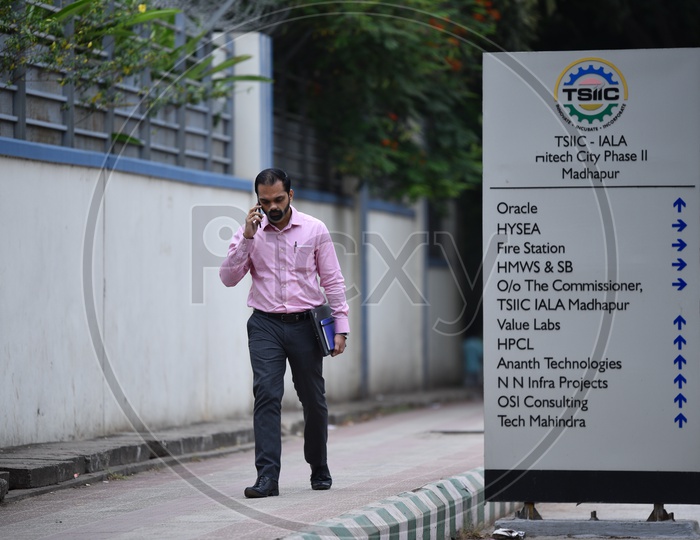 An IT Employee Speaking in Phone and Walking on Foothpath in Hyderabad