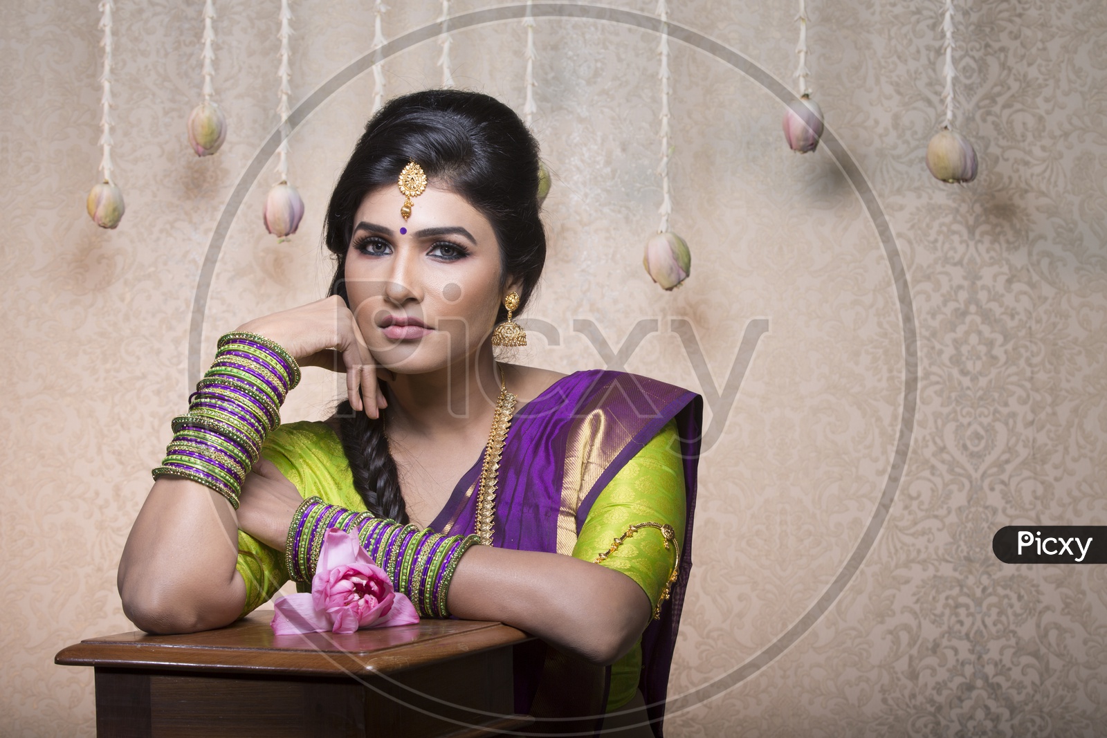 Traditional Indian Female/Woman Model in Purple Saree, green Blouse with a Lotus flower