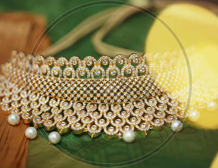 Choker Necklace In Green background - Indian Jewelry/Gold Ornament with White Pearls - Close up