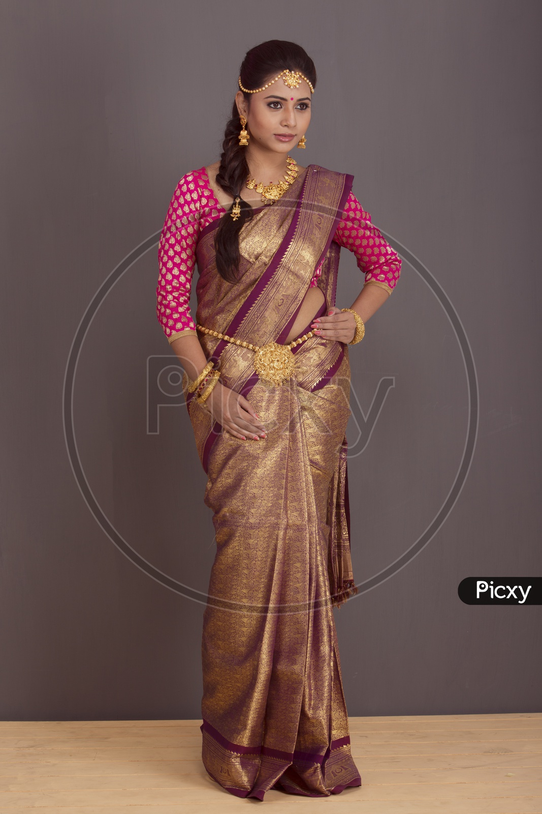Indian bride dressed up in red saree portrait in Studio Lighting / Traditionally dressed up girl