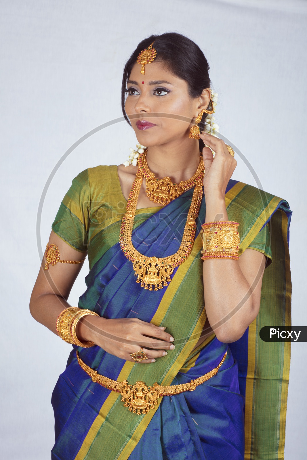 Traditional Indian Female/Woman Model in Blue Saree, green Blouse - Showing her earrings