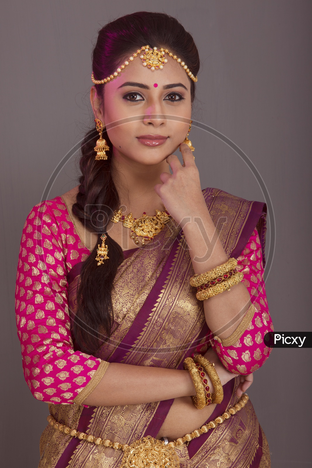 Indian bride dressed up in red saree  portrait in Studio Lighting / Traditionally dressed up girl