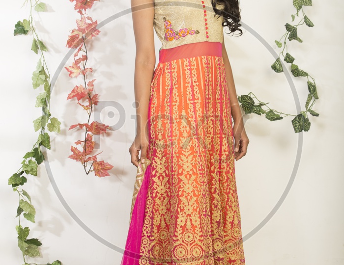An Indian Female Model Wearing a Colorful  Chudidar Over  a Studio Setup and Smiling Looking to Camera